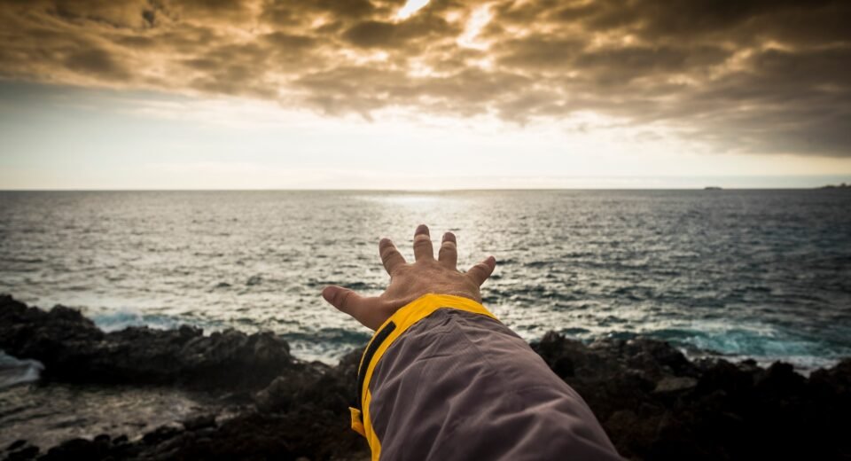adventure concept for man hand like to touch the horizon. free travel spirit